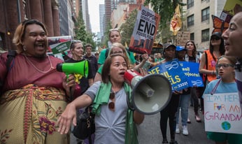 a crowd of activists marching with signs and megaphones